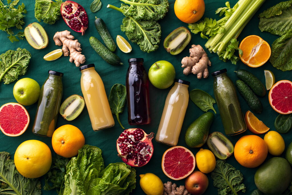 Zum Saftpressen geeignetes frisches Obst und Gemüse, mit 5 Flaschen gepresstem Saft auf dunklem Untergrund (Grapefruit, Apfel, Zitrone, Kiwi, Gurke, Salat, Stangensellerie,...) Zum Saftpressen geeignetes frisches Obst und Gemüse, mit 5 Flaschen gepresstem Saft auf dunklem Untergrund (Grapefruit, Apfel, Zitrone, Kiwi, Gurke, Salat, Stangensellerie,...)