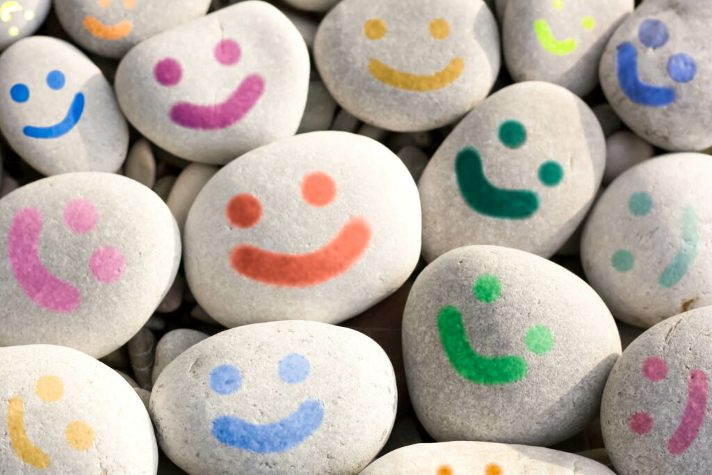 mehrere graue Kieselsteine mit bunten Lach-Gesichtern bemalt, Stein-Smileys mehrere graue Kieselsteine mit bunten Lach-Gesichtern bemalt, Stein-Smileys