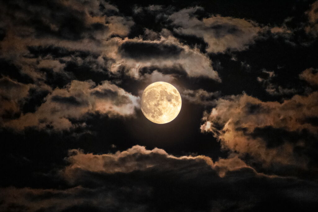 Vollmond am Nachthimmel vor leichten Wolken