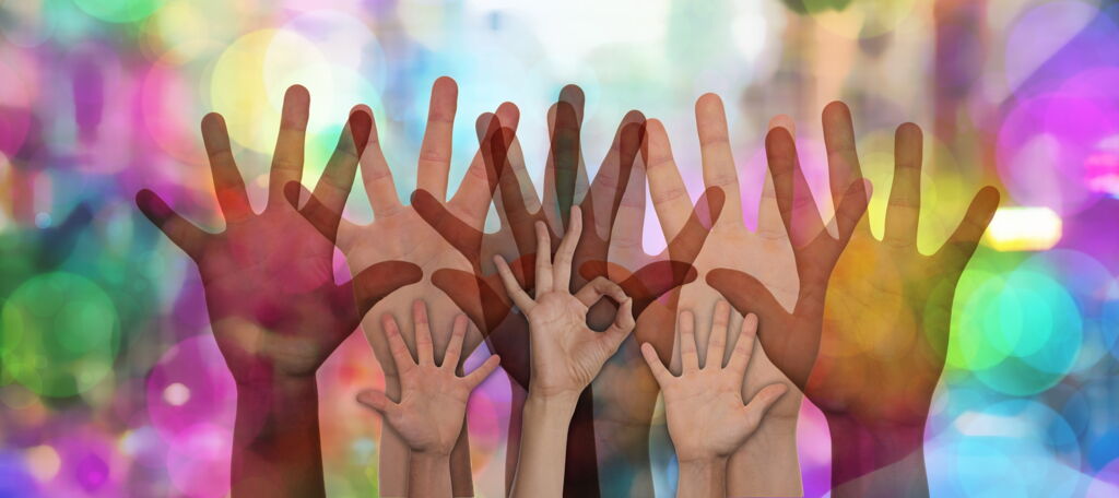 kleine und große Hände mit gespreizten Fingern, die Handflächen nach vorne vor buntem Hintergrund