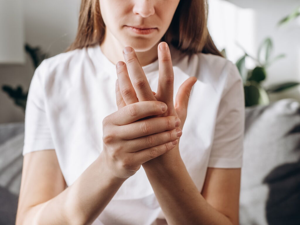 Frau mit Schmerzen in der Hand